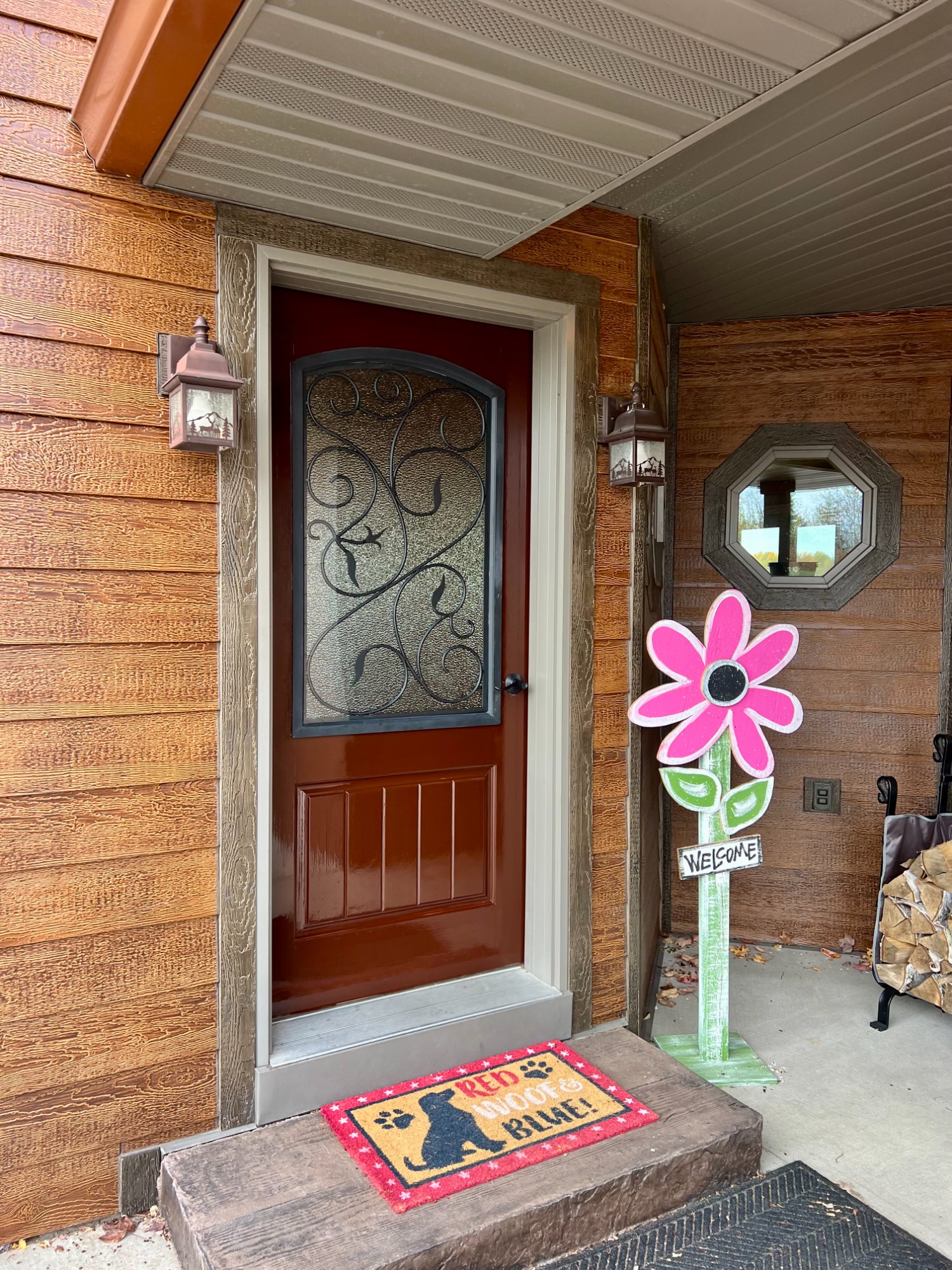 Front entry view showing refinished decorative door with ironwork glass and wood siding