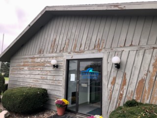 Commercial office building before painting with peeling and weathered siding