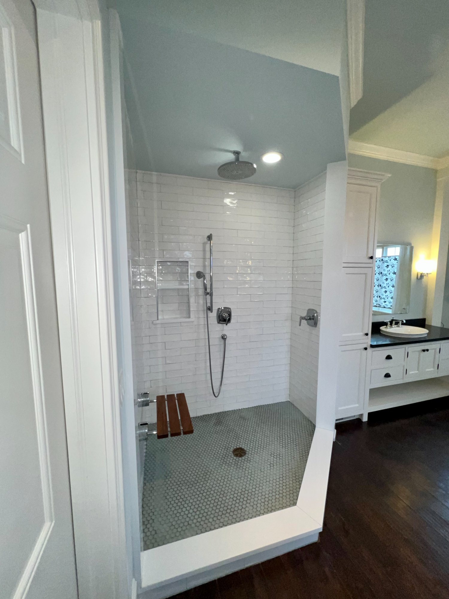 Luxury master bathroom walk-in shower with subway tile, sage green painted ceiling and walls