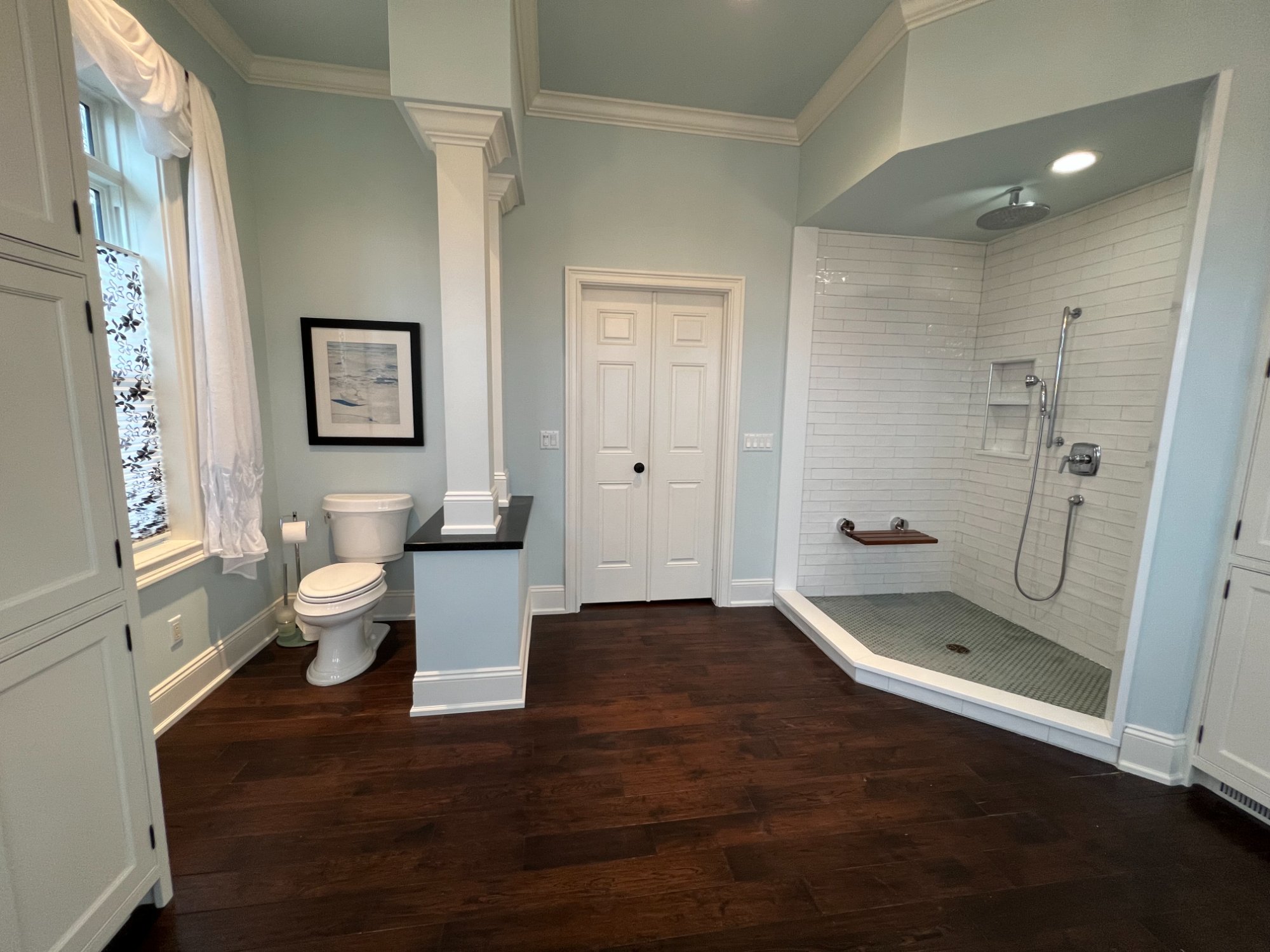 Luxury master bathroom with sage green walls, white trim, crown molding, and walk-in shower