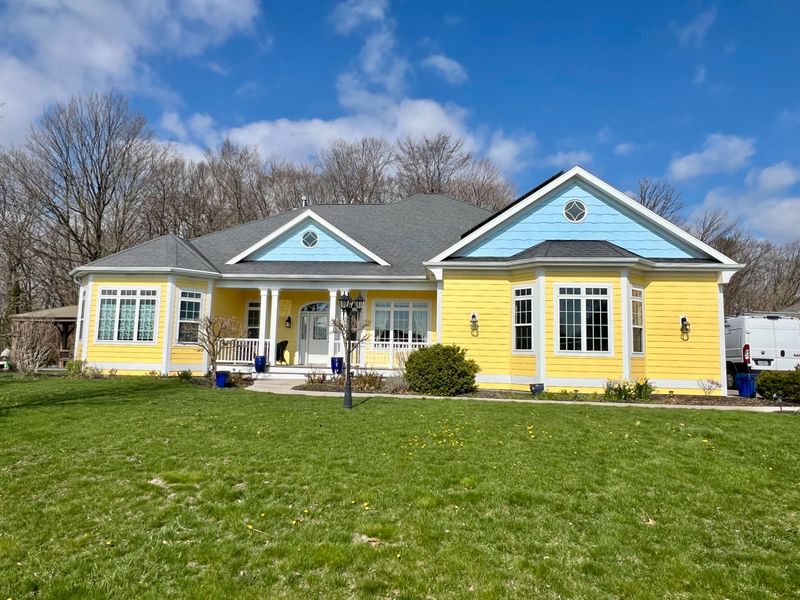 Beautiful exterior house painting with blue and yellow accents by Wisconsin's Best Painters in Manitowoc